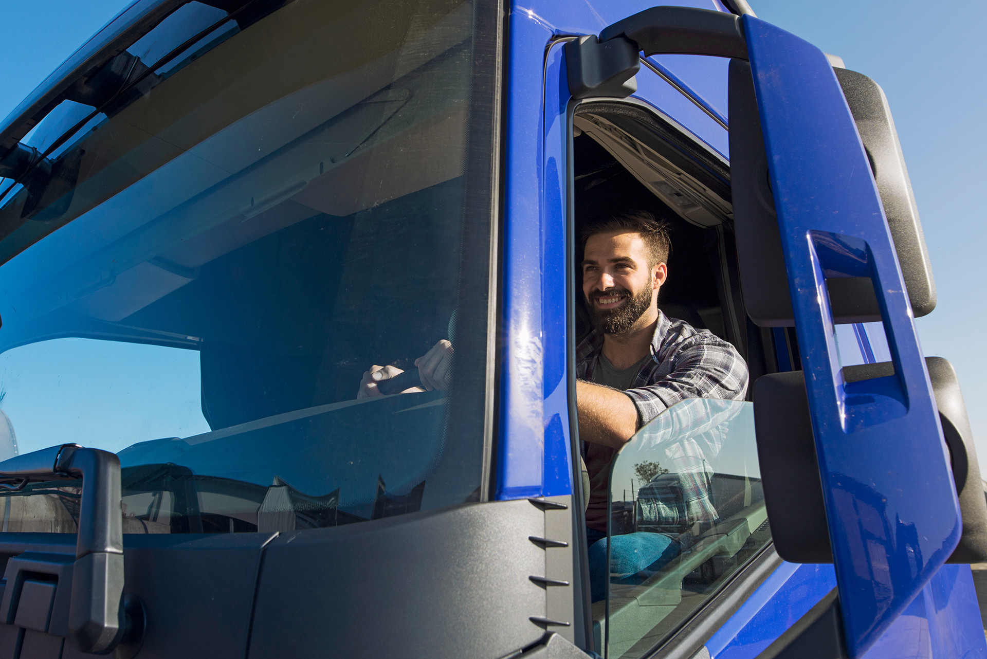 uomo sorride alla guida di un camion