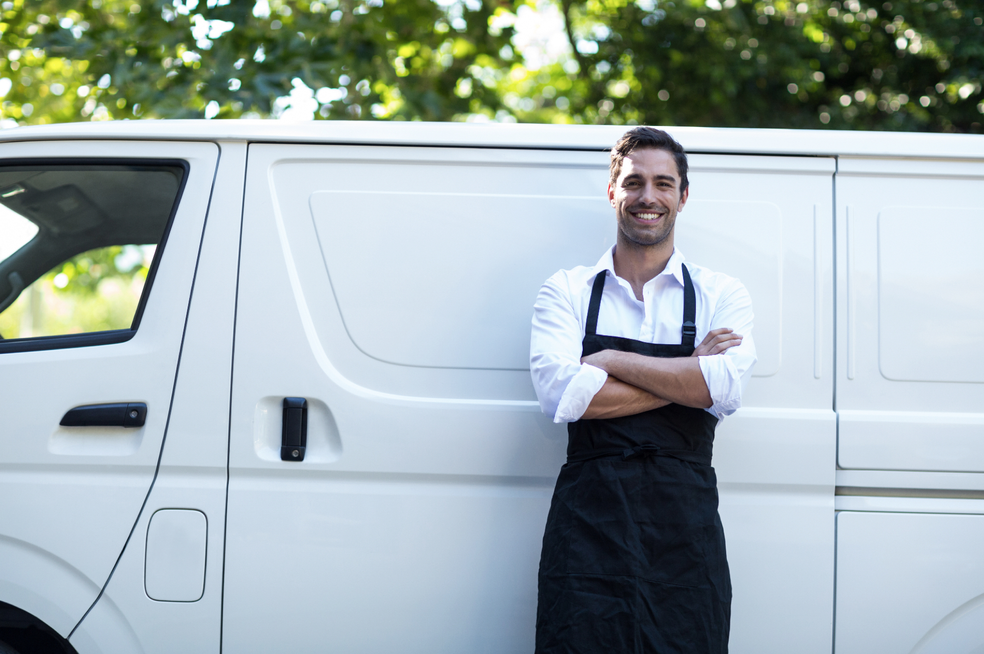 uomo sorridente davanti ad un furgone bianco